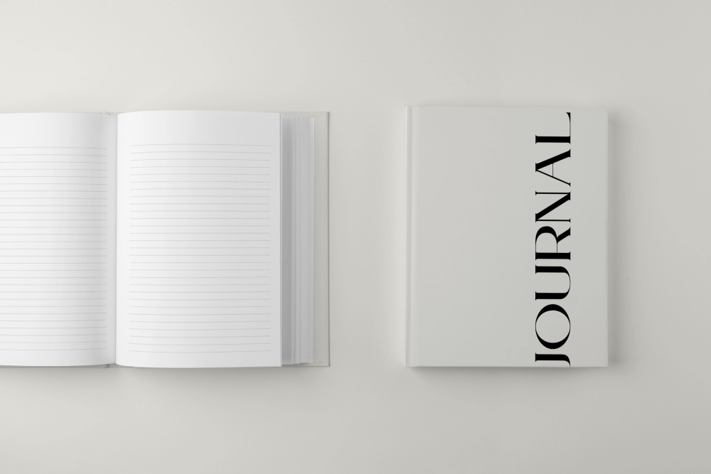 Journal with open pages and cover on a light gray background